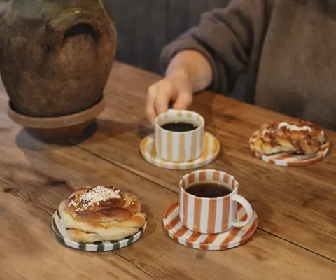 Kvinna håller i en kopp på ett kafé.