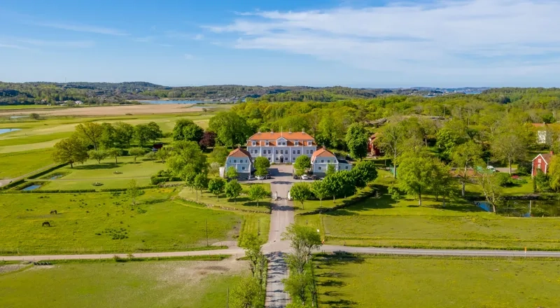 En flygbild av ett stort hus mitt på ett fält.