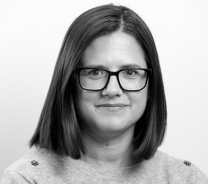A black and white photo of a woman wearing glasses.