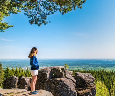 En kvinna står på toppen av en klippformation.