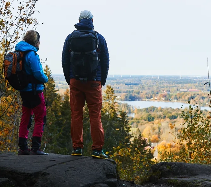 Några personer som står på toppen av ett platåberg. I bakgrunden syns en utsikt med höstträd och sjöar.