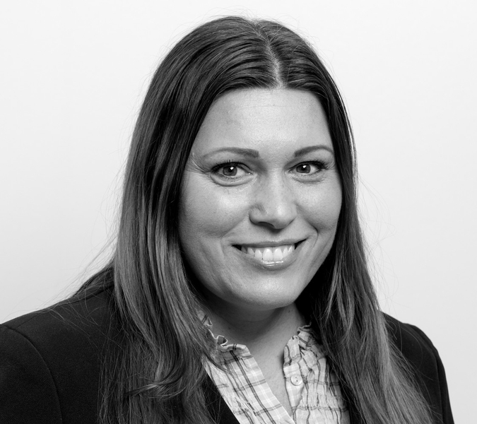 A black and white photo of a woman smiling.