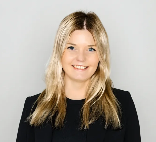 En kvinna klädd i svart jacka och svarta byxor.