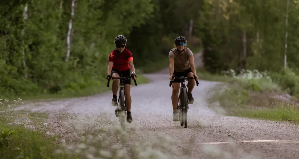 Cyklister på en grusväg i skogen.