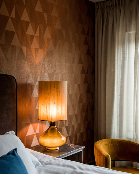 Lamp on a bedside table in a hotel room.