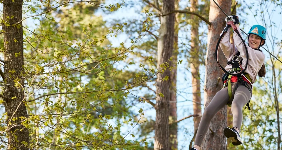 En person på en linbana i skogen.