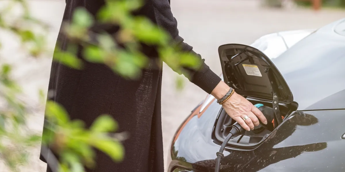 Kvinna som laddar en elbil.