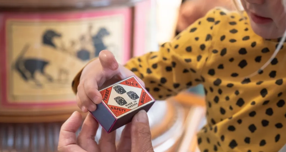 En kvinna håller en tärning med ett hundmotiv på.