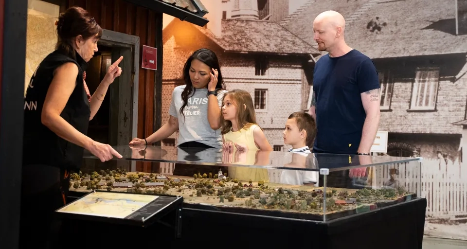 En grupp människor som står runt en modell över Tidaholm