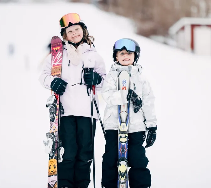 Några personer som står på toppen av en snötäckt sluttning.
