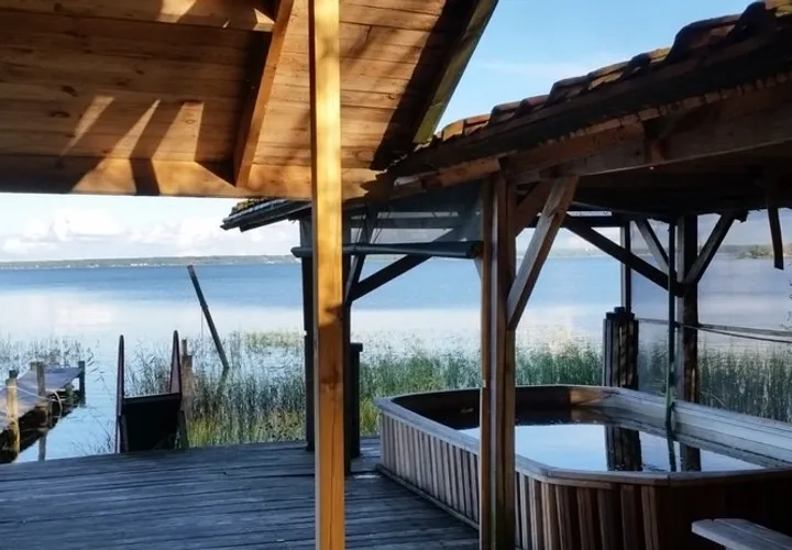 En badbalja i ett trädäck med tak över och Vänern i fonden.
