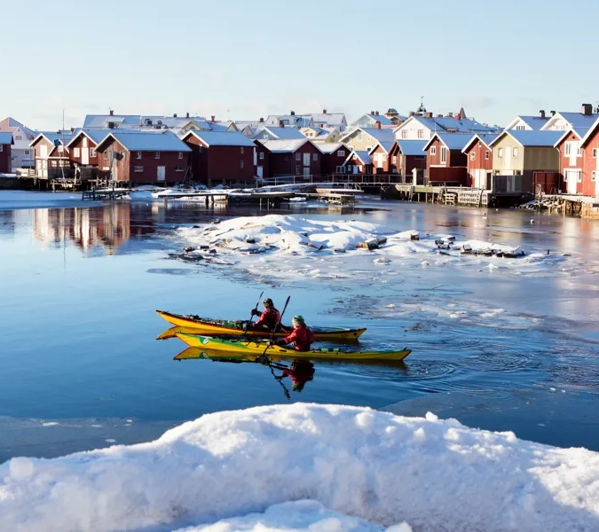 Några personer i en gul kajak på ett vattendrag.