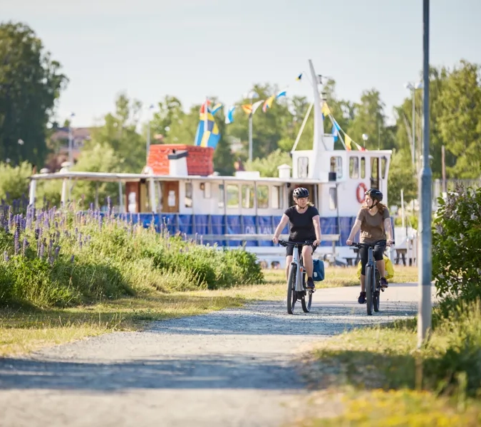 Några personer som cyklar på en grusväg.