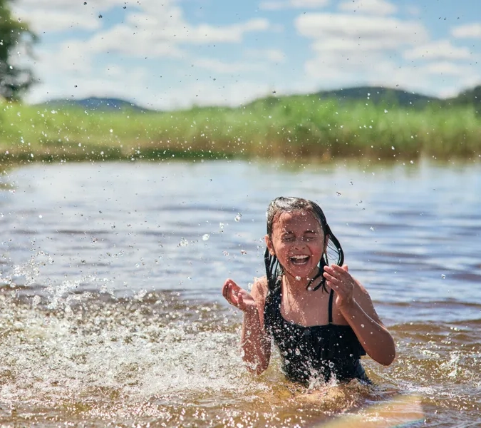 En ung flicka leker i vattnet.