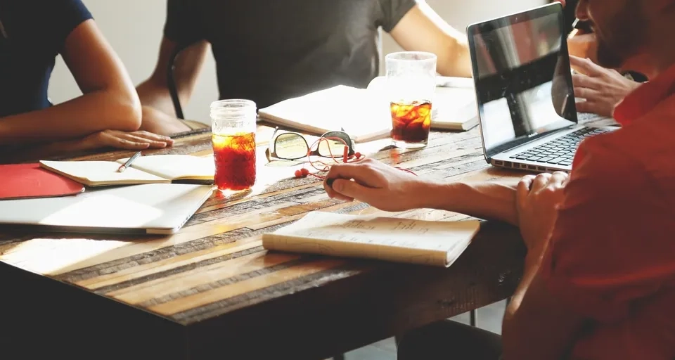 En grupp människor som sitter runt ett träbord.