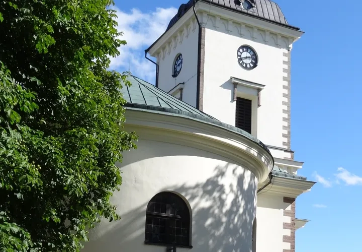 A white building with a clock on the top of it.