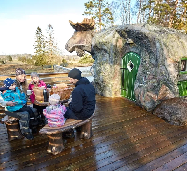 En grupp människor som sitter runt en träbänk.