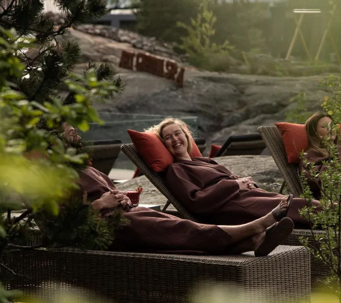 A woman laying on top of a couch next to a tree.