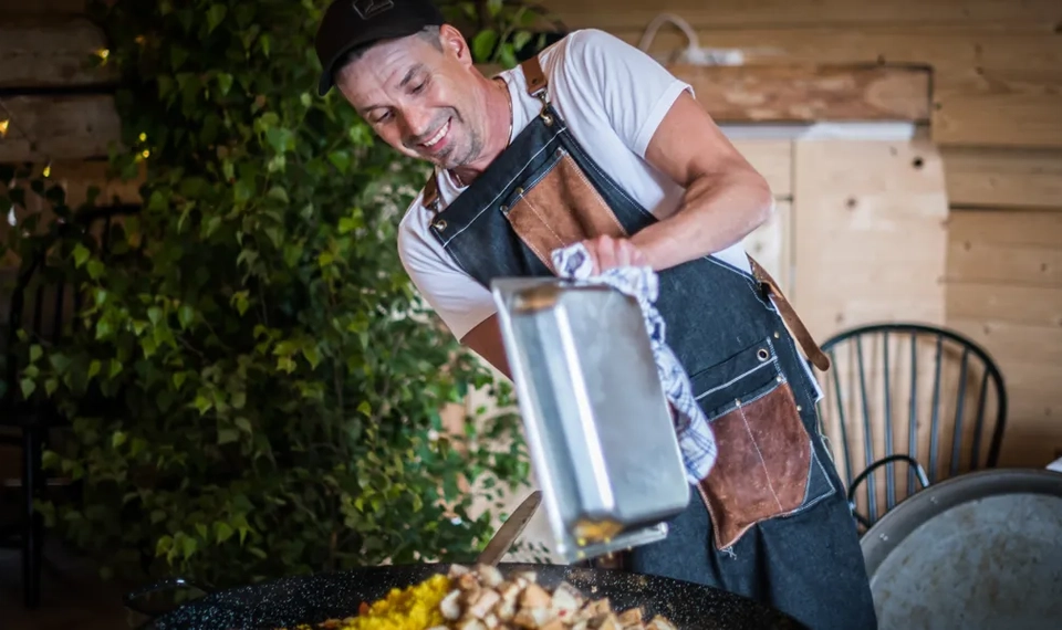 En man i förkläde lagar mat.