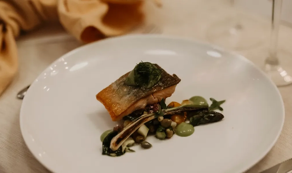 En vit tallrik som toppas med en bit mat.