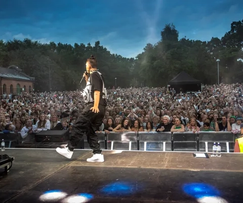 En artist som står på scen framför ett folkhav