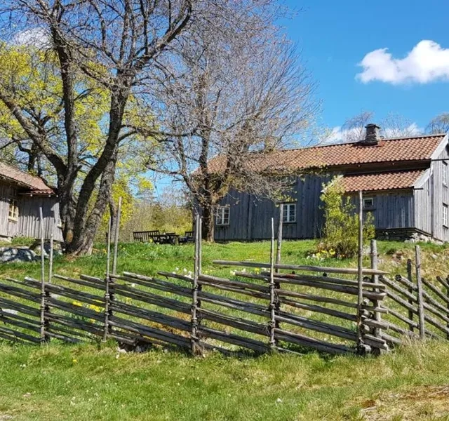 A farm with a fence and a barn in the background.