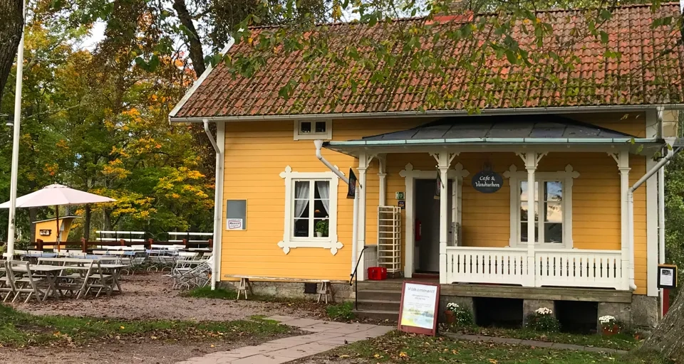 A small yellow house with a red roof.