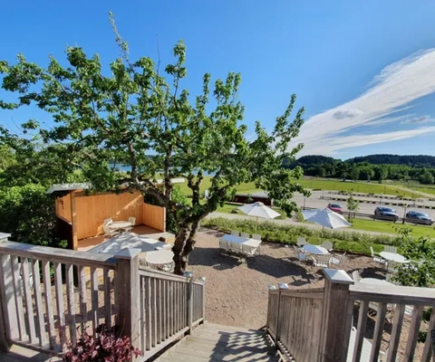 Ett trädäck med träd och picknickområde.