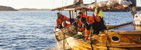 A group of people on a boat in the water.