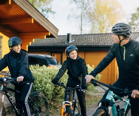 En grupp människor står med cyklar bredvid varandra.