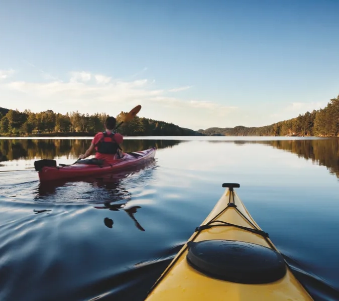 A person in a kayak paddling on a lake.
