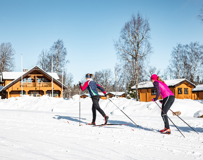 Några personer som åker skidor över snötäckt mark.