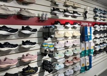 En vägg med sportskor som visas upp i en butik.