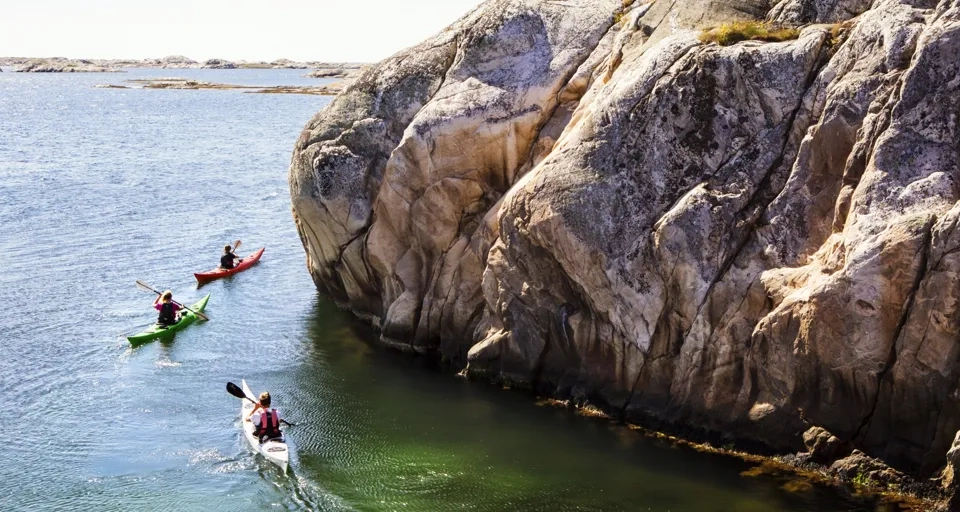 Två personer i kanoter paddlar på vattnet.
