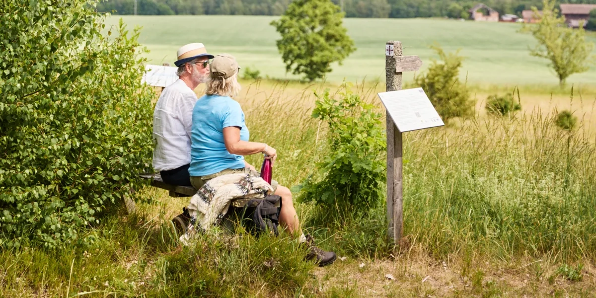 Två personer sitter på en bänk och vilar.
