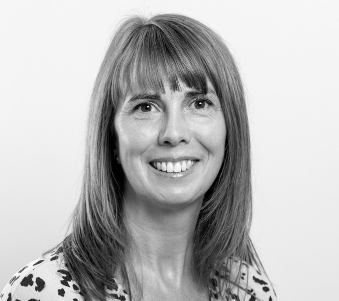 A black and white photo of a smiling woman.