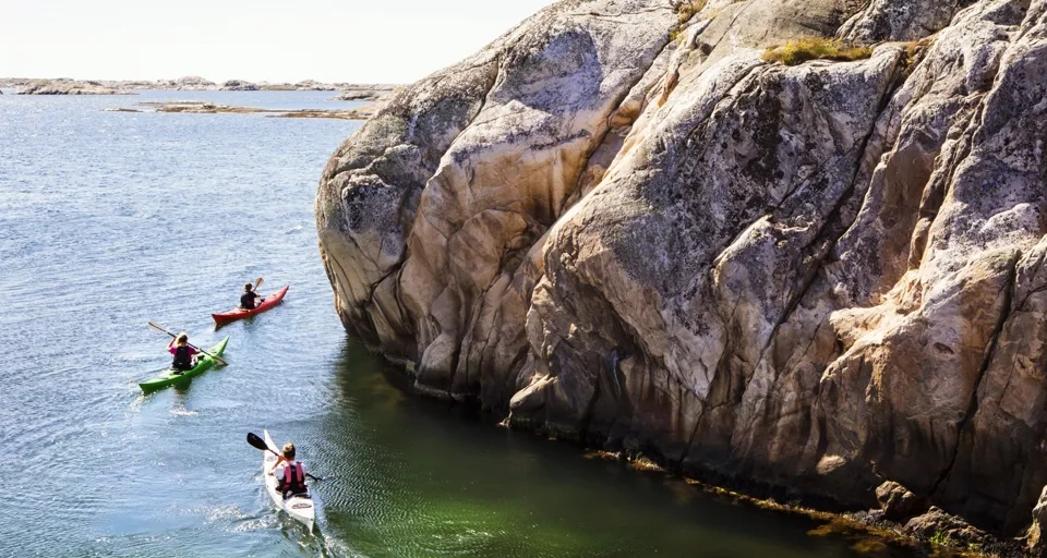 To personer i kanoer padler på vannet.