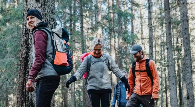 Människor vandrar i skog