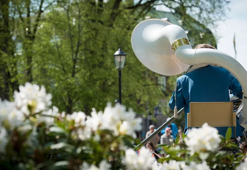 En man i blå skjorta bärande på en stor vit tubal.