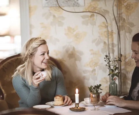 Kvinna fikar på kanelbulle och kaffe