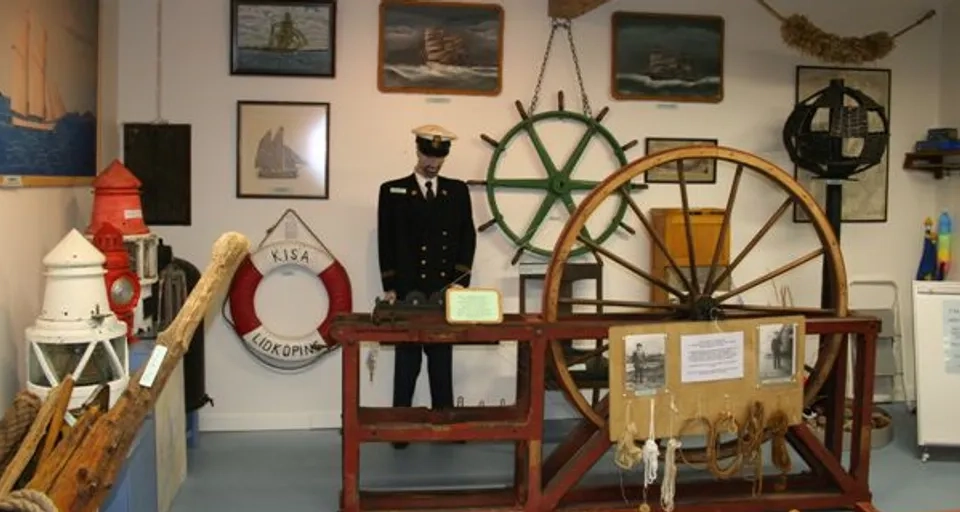 A man standing in a room with a spinning wheel.