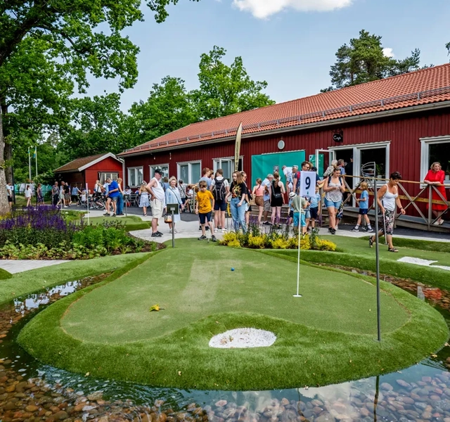 Äventyrsgolfbana med människor i bakgrunden