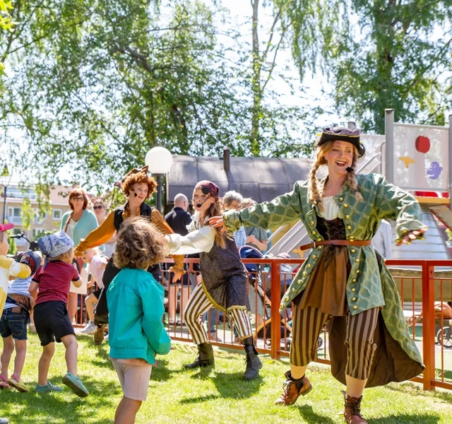 En grupp människor som står och väntar i en park.