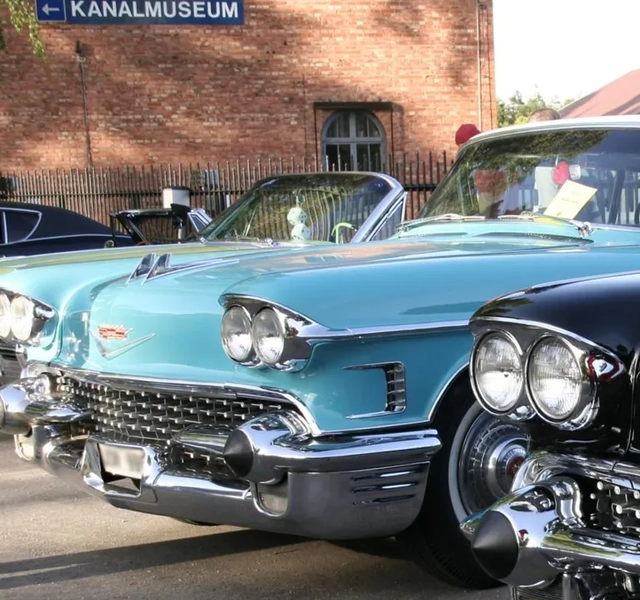En rad klassiska bilar parkerade bredvid varandra.
