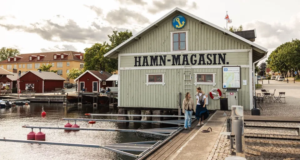 Eine Gruppe von Menschen, die vor einem Gebäude an einem Gewässer steht.