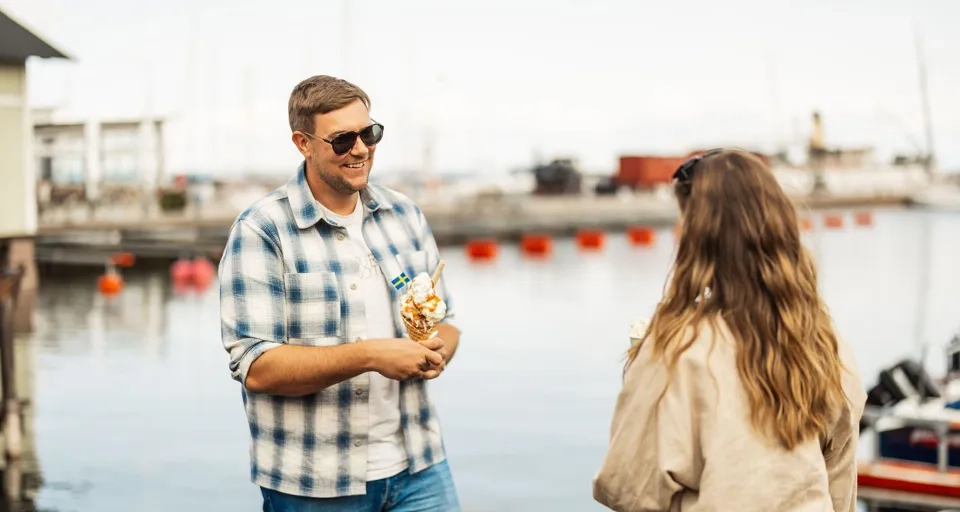 Ein Mann steht neben einer Frau in der Nähe eines Gewässers.