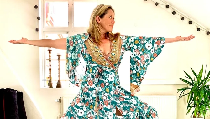 En kvinna i långklänning dansar på ett hårt trägolv.