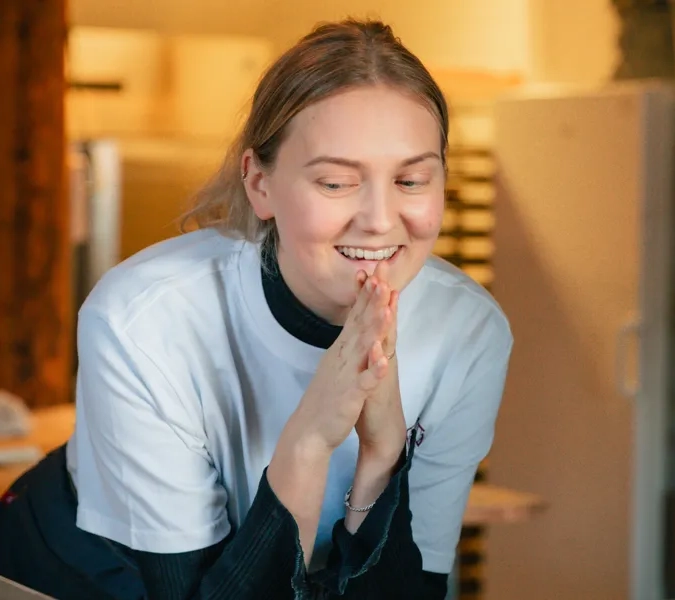 A woman sitting at a counter in a kitchen.
