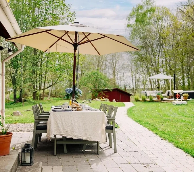 A patio with a table and chairs under an umbrella.