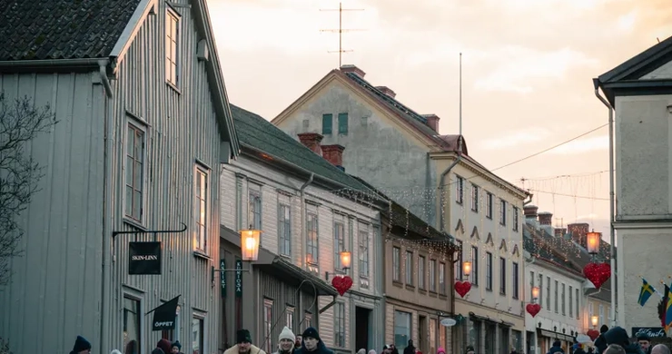 A crowd of people walking down a street next to tall buildings.